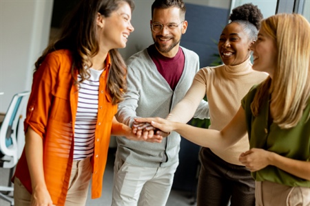 Adultos unen sus manos en símbolo de trabajo en equipo y colaboración. Imagen representativa del espíritu emprendedor en comunidad de FEPEP.