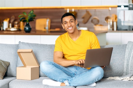 Joven emprendedor usando su portátil para publicar un clasificado desde casa, aprovechando las herramientas digitales de FEPEP.
