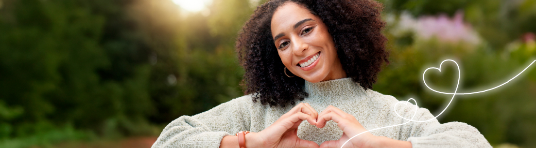 Mujer sonriente formando un corazón con sus manos, representando el compromiso y la vocación de servicio de FEPEP hacia sus afiliados.