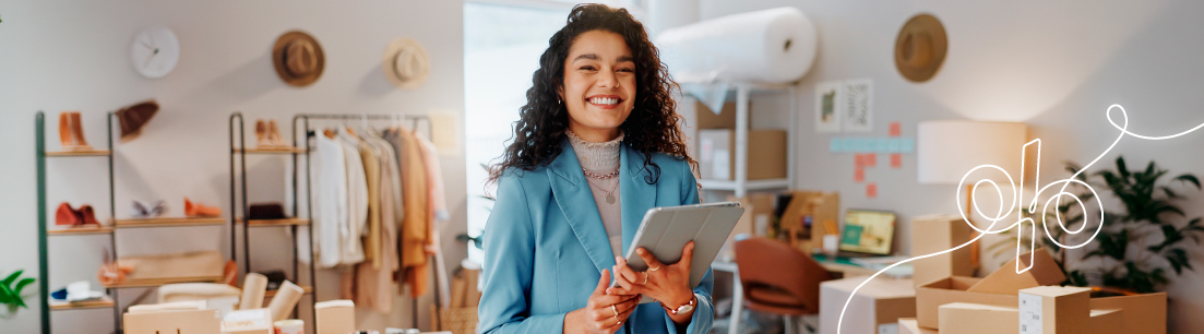 Mujer emprendedora en su tienda, sonriendo mientras usa su tablet, representando las oportunidades y beneficios de los convenios y alianzas de FEPEP.