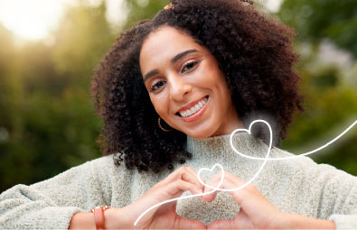 Mujer sonriente formando un corazón con sus manos, representando el compromiso y la vocación de servicio de FEPEP hacia sus afiliados.
